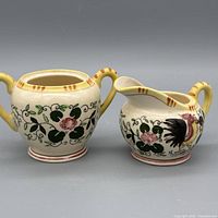 Front view of both earthenware pieces displaying rooster and floral decoration