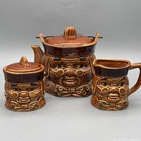 Full view of teapot, creamer, sugar bowl showing design and glaze