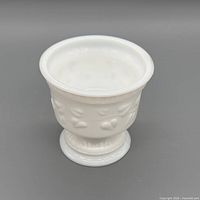 front view of white milk glass planter-compote with embossed motif