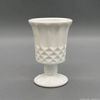 Front view of white milk glass goblet showing diamond hobnail body and pedestal foot