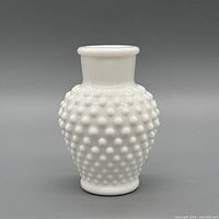 Front view of white milk glass hobnail vase