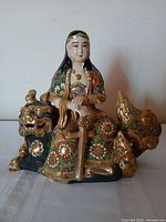 Front view of Kannon figurine on shishi lion