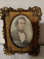 Front view showing ornate gilt frame and oval photographic portrait