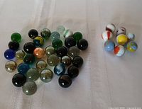 All marbles grouped on white cloth showing quantity and colour range