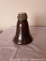 Side view of brown glazed ceramic bell