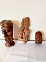 Front view of three wood carvings displaying size and detail