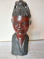 Front view of carved wood African female bust showing facial details and finish