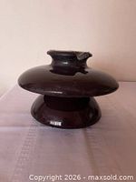 Top view of brown porcelain insulator showing shape and glaze