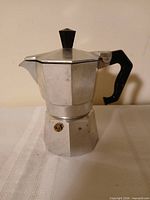 Side view of octagonal aluminum moka pot with black handle
