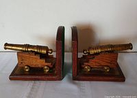 Side view of both cannon bookends showing barrels and wooden carriages