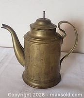 Side view showing full coffee pot, gooseneck spout, loop handle, lid in place