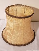 Angled view showing overall shape, vellum texture, brown braid trim