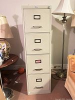 Full front view of beige 4-drawer metal filing cabinet showing all drawers and overall condition