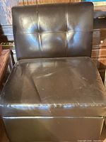 Front view of slipper chair showing upholstery and tufted back