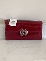Front view of merlot patent leather Coach wallet showing turn-lock