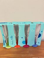 Front of boxed set showing four flutes with colored stems