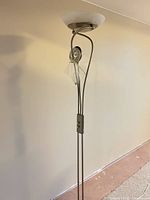 Full view of brushed nickel floor lamp with upper torchiere shade and lower reading light arm