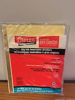 Front view of sealed packs showing Staples branding, quantity, tab count, letter size