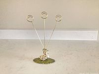 Full view of photo holder showing three gold clips and overall form