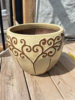 Full view of cream glazed ceramic planter with vine motif