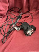 Spotlight with coiled AC cord and clamp visible