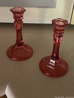 Pair of cranberry glass candlesticks side by side