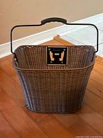 Front view of plastic wicker bike basket showing weave, handle and mounting plate