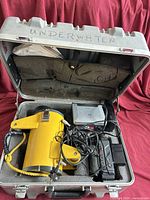 Open case showing Shark Marine housing, Sony recorder, charger, batteries, cables and foam interior