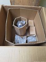 Unopened box showing nested cardboard and bubble-wrapped chandelier parts