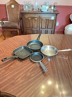 All four frying pans displayed on table