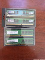 Two plastic cases each containing two DDR2 DIMMs