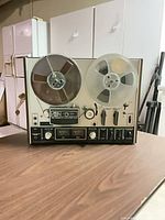 Front view showing controls, reels, meters, wood cabinet