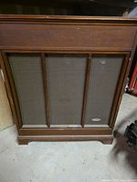 Front view showing three-panel speaker grille and badge