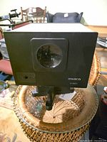 Front view showing Ambico label, lens window, and tripod mount