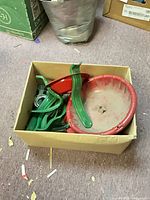 box containing mixed Christmas tree stand parts