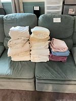 Stack of assorted colored fitted sheets on couch