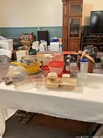 All items arranged on table showing variety of containers, bowl, colander, sieve, jars and measuring cup