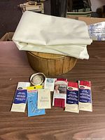 Fabric, wooden box, packaged trims, needles, buttons displayed