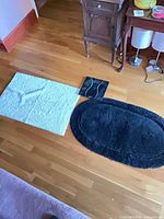 Group shot of bath mat, rug, and scale on floor