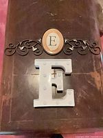 Front view of both items showing marquee letter and metal scroll plaque