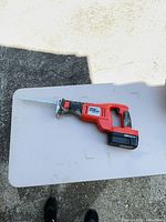 Reciprocating saw with battery and blade on table