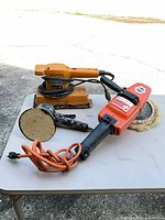 Orbital sander, rotary polisher with wool pad and auxiliary handle on table