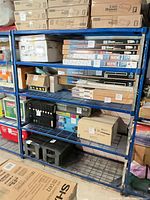 Front view of first blue wire shelving unit loaded with boxes (contents not included)