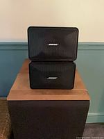 Front view of stacked Bose 101 speakers showing grilles and logos