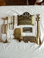 Group shot of all seven brass items laid out on cloth