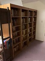Four assembled brown veneer bookshelf units side by side