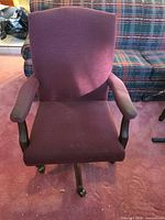 Front view of burgundy upholstered executive office chair with wooden arms and five-spoke caster base