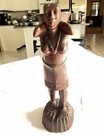 Front view of carved wooden female figure sculpture
