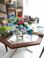 Overall lot of boxed and packaged cleaning supplies on glass table
