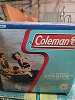 Front of original Coleman box showing Evasive 2-3 person tube with image of riders